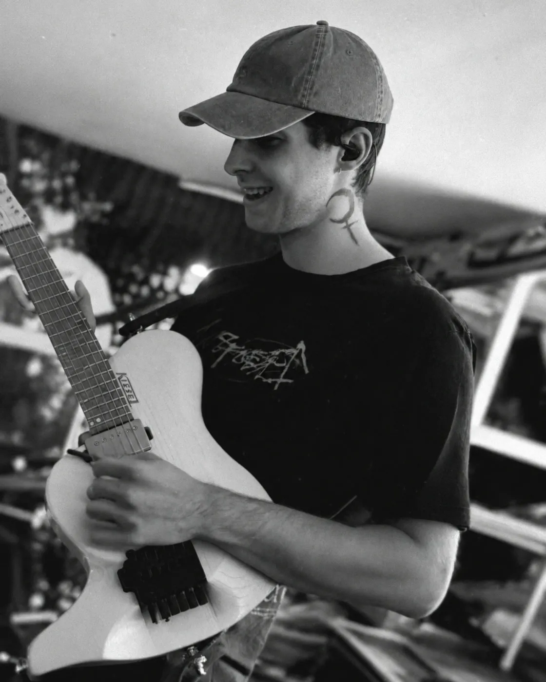 Hauke spielt in einer Schwarzweißaufnahme eine weiße E-Gitarre
